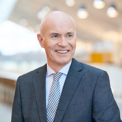 Portrait von Prof. Dr. Götz E. Rehn, Gründer und Geschäftsführer von Alnatura. Der Hintergrund ist unscharf und zeigt den Alnatura Campus von innen.