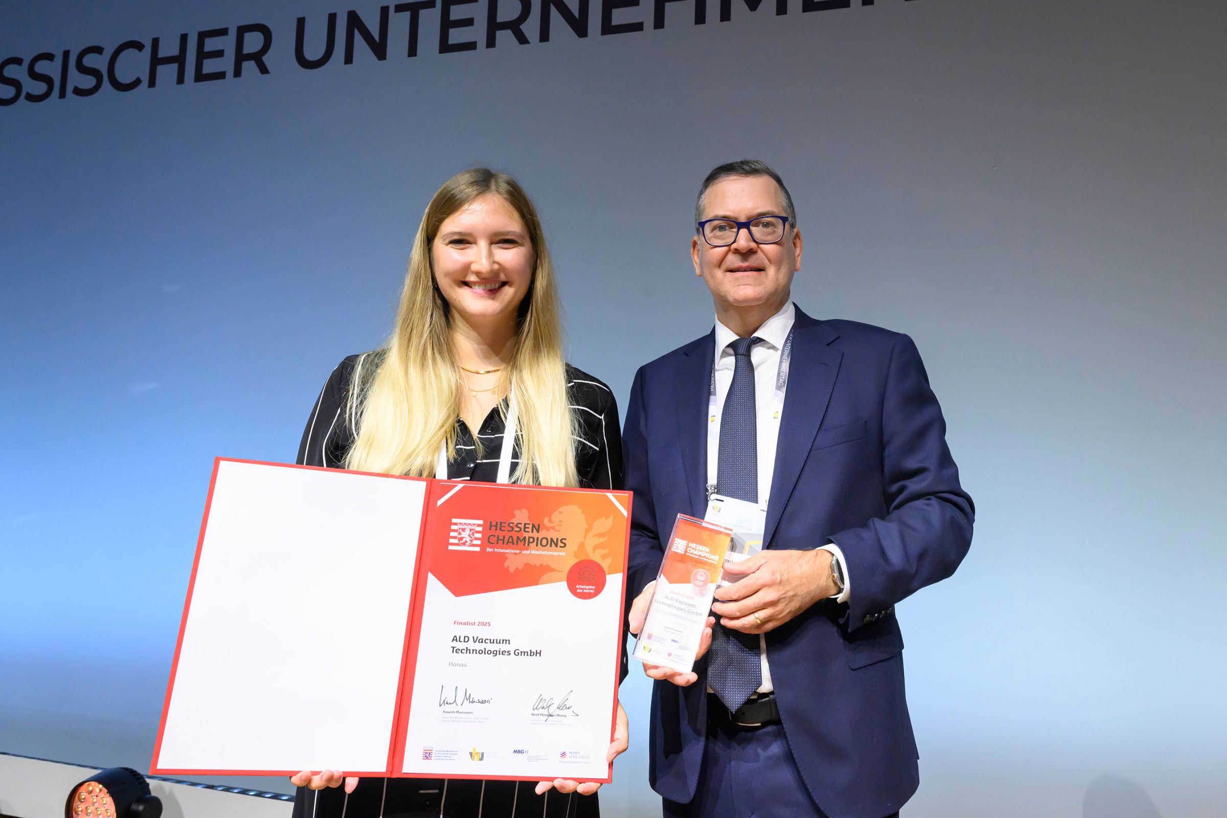 ALD Vacuum Technologies GmbH | Jennifer Lieb, Dr. Helmut Becker auf der B&uuml;hne mit Urkunde und Pokal