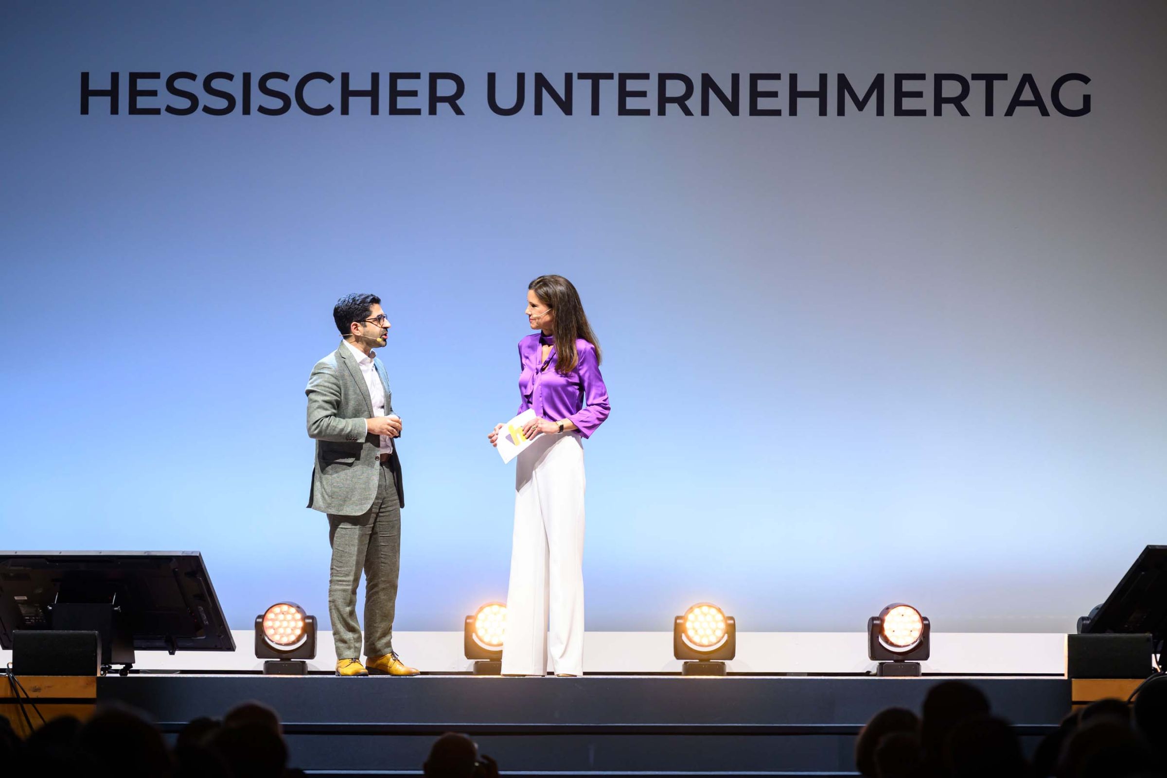 Wirtschaftsminister Kaweh Mansoori und Moderatorin Corinna Egerer auf der B&uuml;hne im Wiesbadener Kurhaus