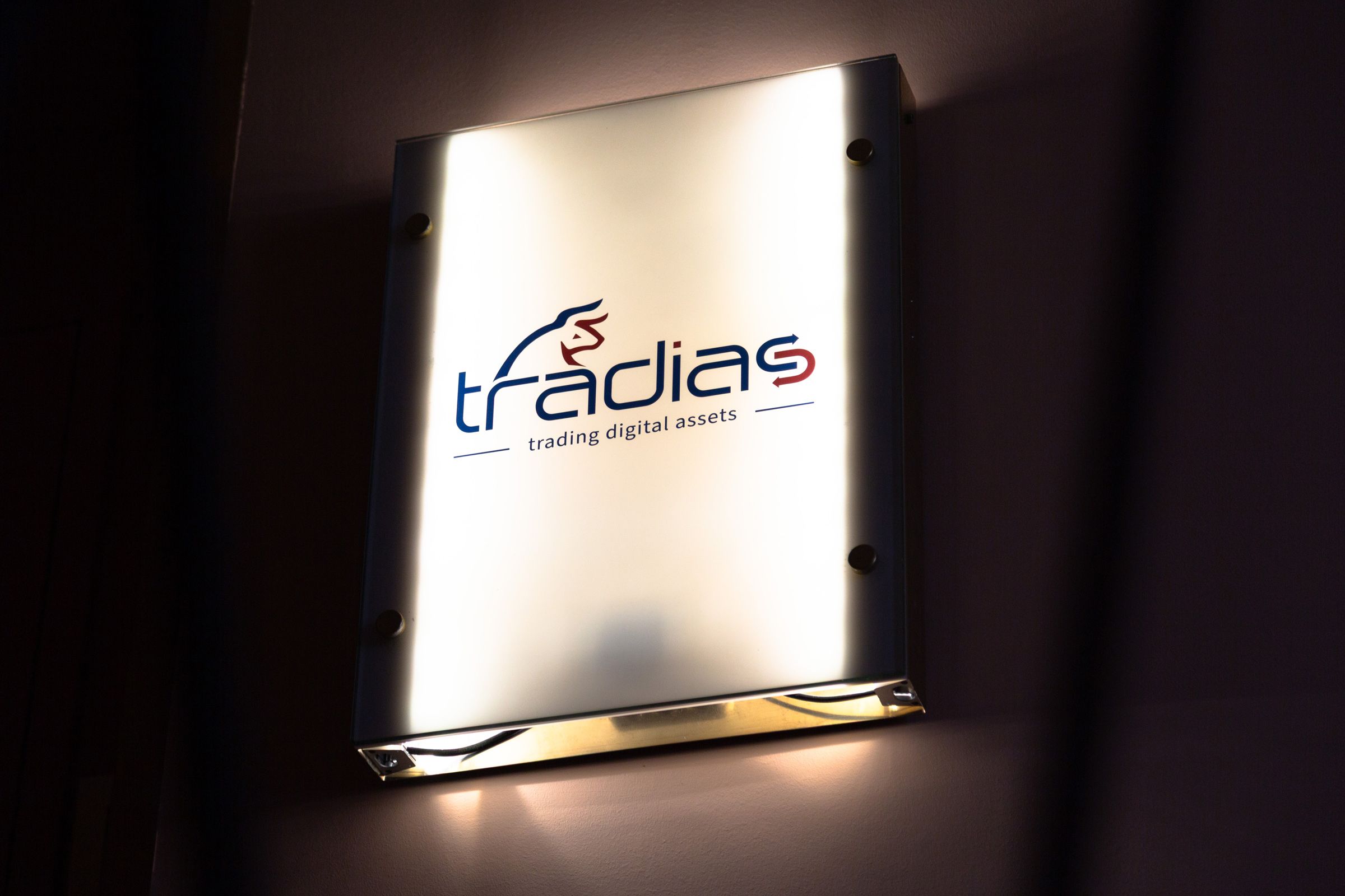 Hinterleuchtetes Schild mit dem Logo von Tradias - trading digital assets -