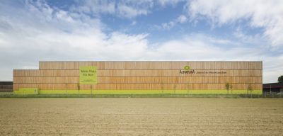Außenansicht auf das gesamte Gebäude des Verteilzentrums von Alnatura, hinter einem Feld in Lorsch.