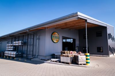 Lagerhalle Energiesysteme Groß von außen, ein großes Logo an der Wand und ein paar Paletten stehen vor der Eingangstür